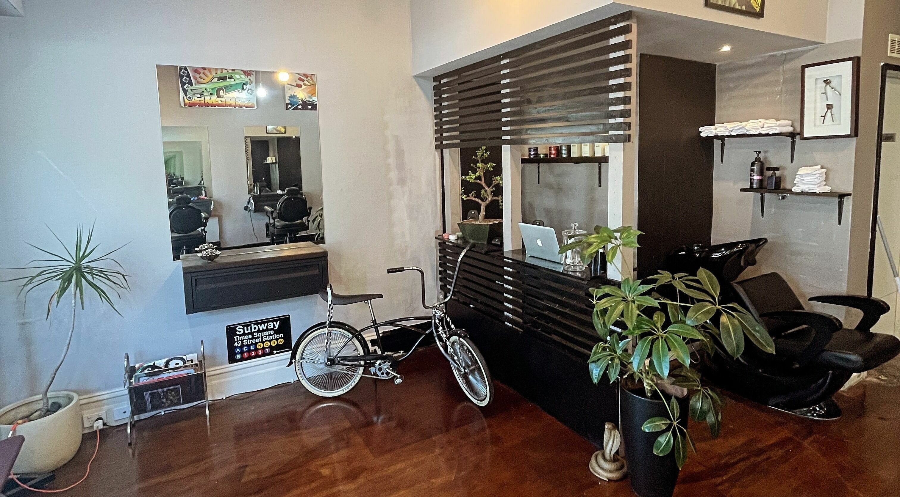 Modern interior of Chop Chop Barbers, Melbourne, Victoria, AU, featuring stylish decor with bicycle and plants.