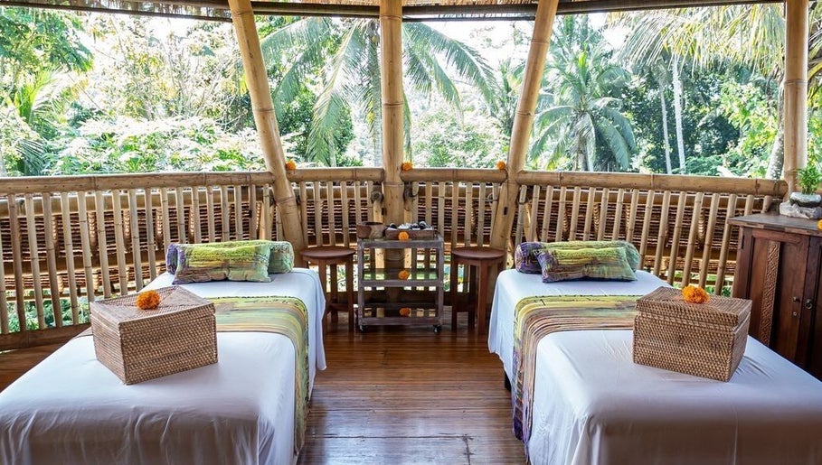 Tropical spa setup at Flying Bamboo Spa, Bali, Bali, ID featuring two bamboo massage tables overlooking greenery.