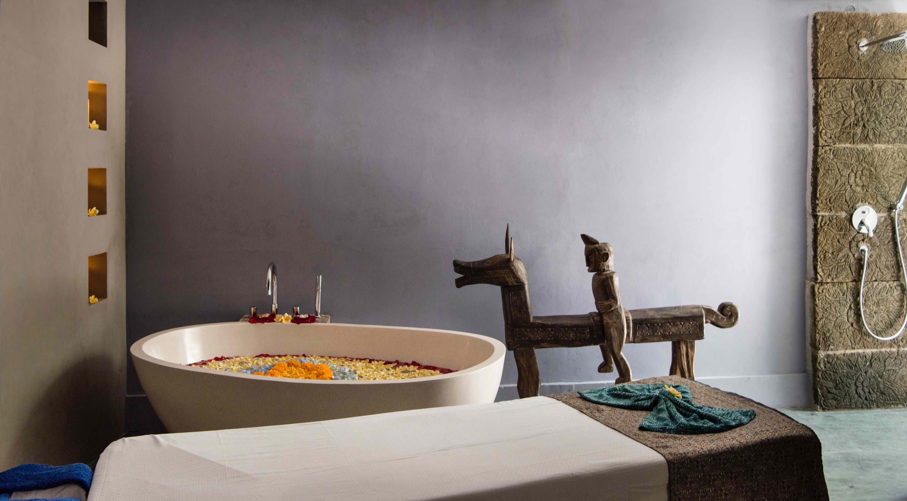 Luxurious bath setup at Mudara Spa in Bali, Bali, ID, with floral accents and unique decor.