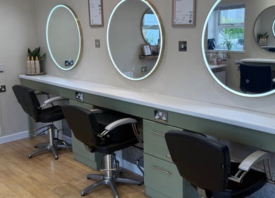 Modern styling area with round mirrors at Polgooth Village Salon, Polgooth, England, GB.