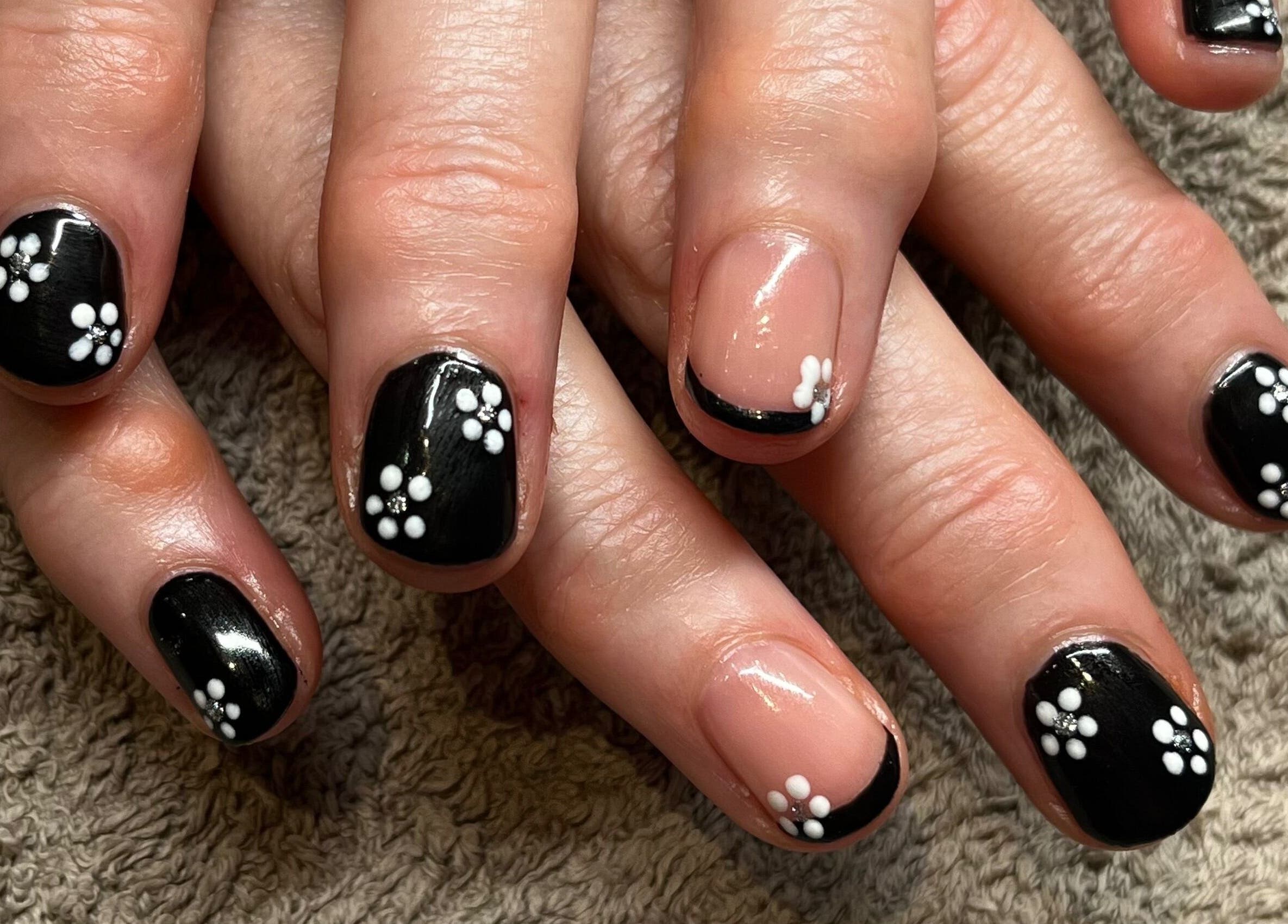 Stylish floral nail art at Polgooth Village Salon, Polgooth, England, GB, showcasing intricate black and white design.