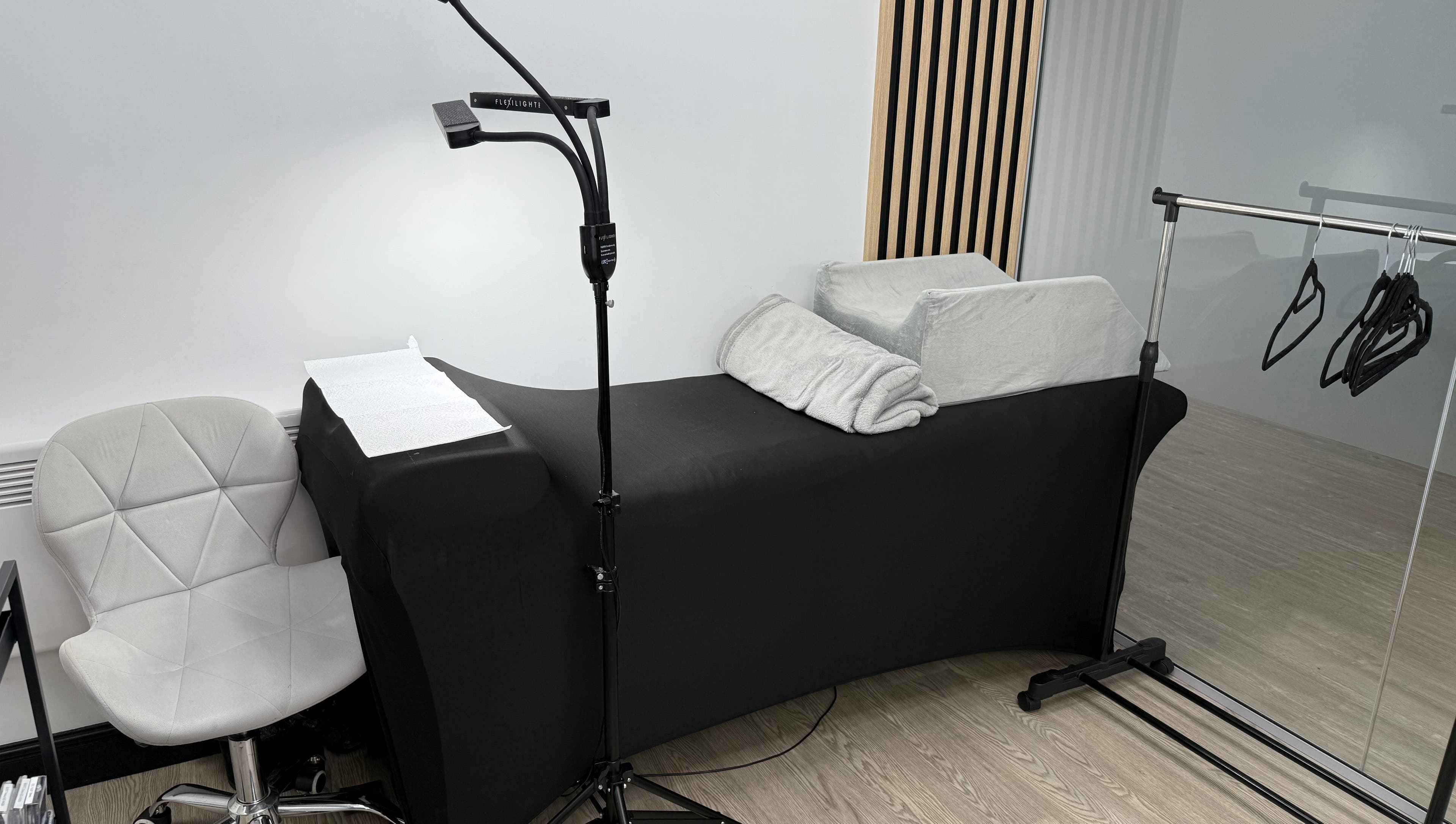 Cozy treatment area at Yanaalash, Manchester, England, GB, featuring a modern chair and therapy bed.