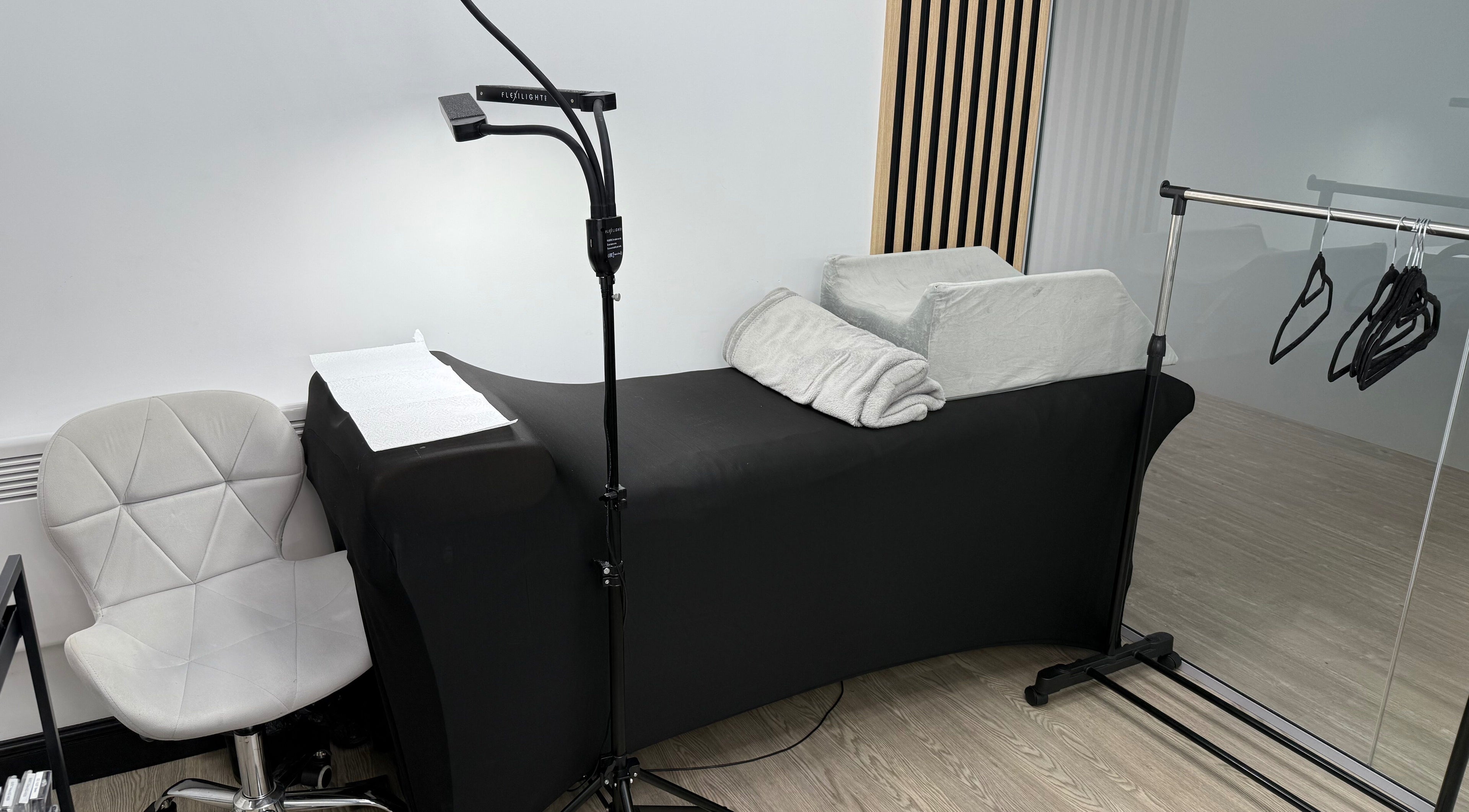 Cozy treatment area at Yanaalash, Manchester, England, GB, featuring a modern chair and therapy bed.