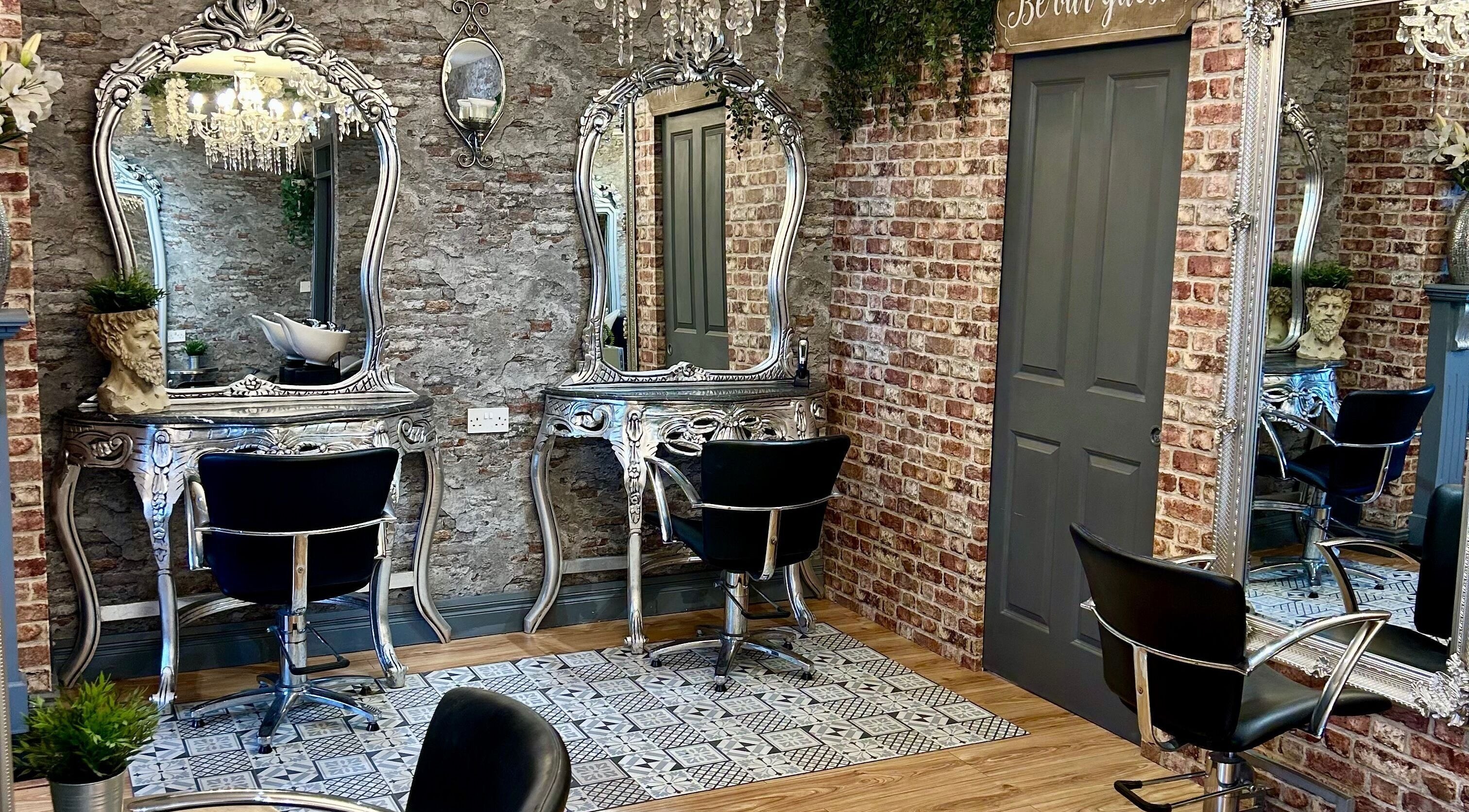 Elegant styling stations at Hair Factory, Prosperous, County Kildare, IE featuring ornate mirrors and chairs.