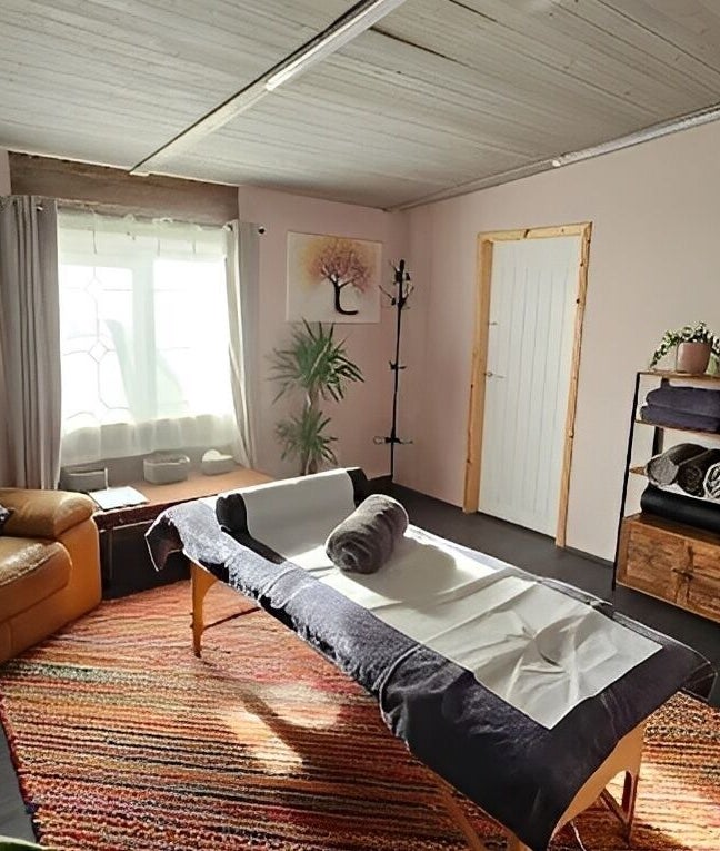Relaxing massage room at The Muscle Medic, Walton Highway, England, GB with cozy decor and ambient light.