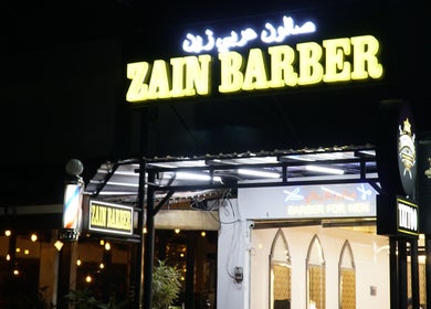 Night view of Zain Barber Legian Kuta entrance in Bali, Bali, ID with illuminated signage.