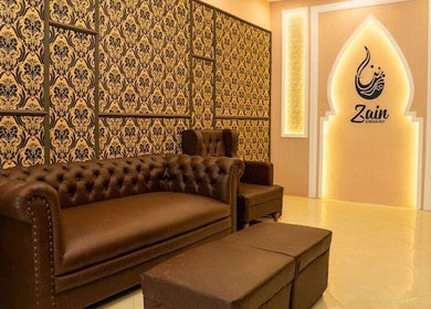 Elegant brown seating area in Zain Barber Canggu, Bali, Bali, ID with ornate wallpaper.