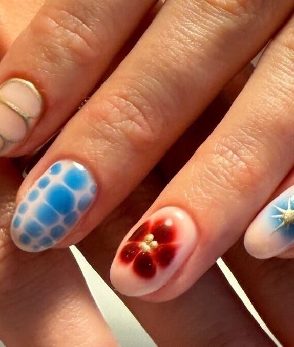 Intricate nail art at Juicy Jels, Melbourne, Victoria, AU featuring vibrant blue and red designs.