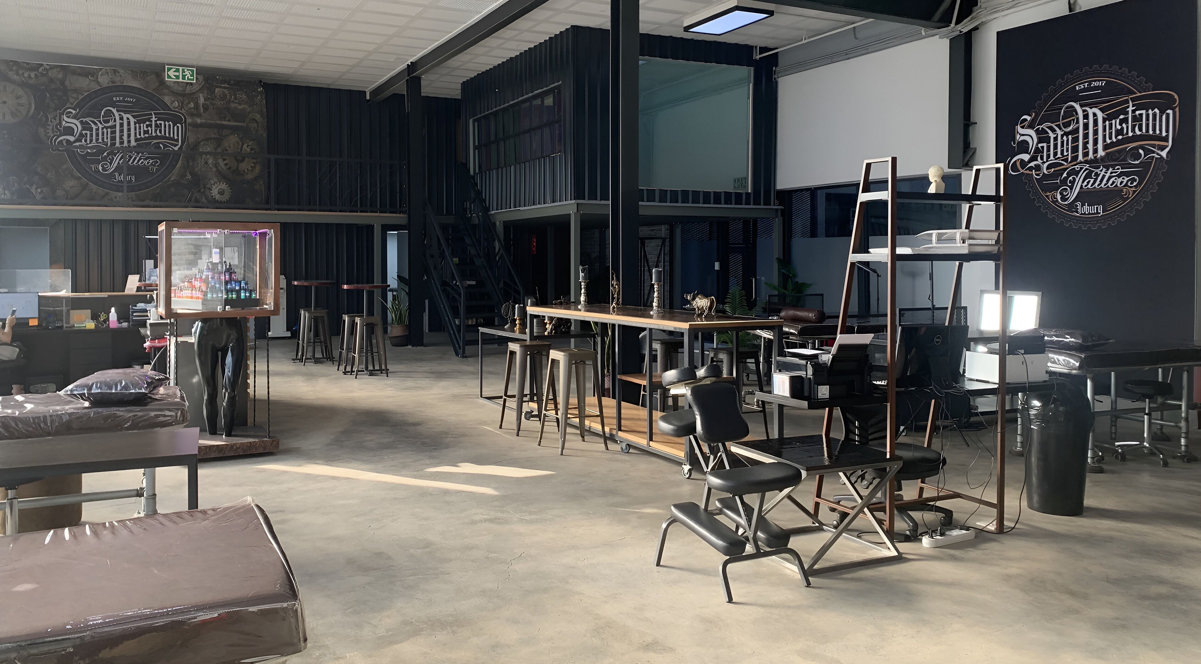 Spacious interior of Sally Mustang Tattoo Joburg in Johannesburg, Gauteng, ZA, with stylish seating and decor.