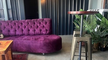 Purple sofa in modern decor at Sally Mustang Tattoo Joburg, Johannesburg, Gauteng, ZA.