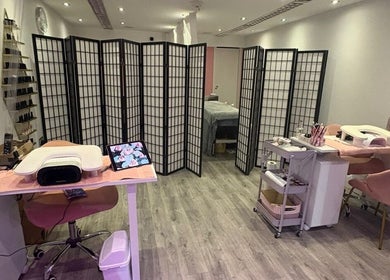 MISSY Aesthetics & Gals salon interior with chic decor in Douglas, IM featuring nail stations and modern partitions.