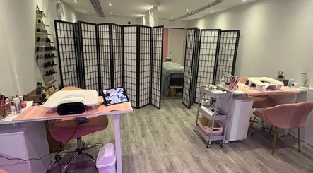 MISSY Aesthetics & Gals salon interior with chic decor in Douglas, IM featuring nail stations and modern partitions.