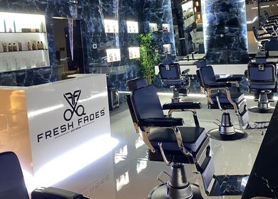 Interior of Fresh Fades Mens Barbershop in Dubai, AE, featuring sleek chairs and modern decor.