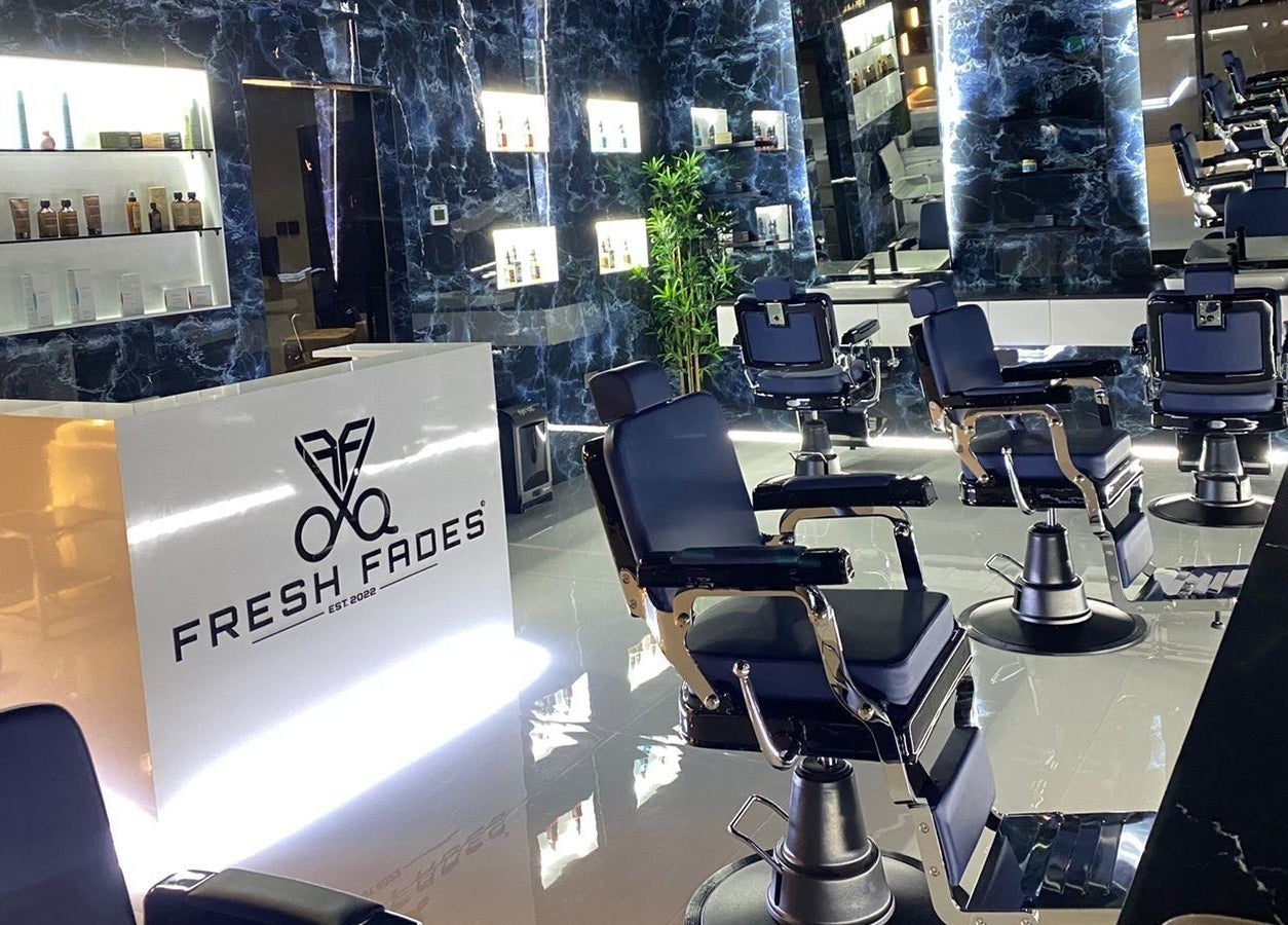 Stylish interior of Fresh Fades Mens Barbershop in Dubai, Dubai, AE with modern barber chairs and illuminated decor.