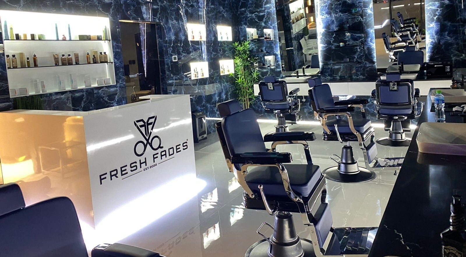 Stylish interior of Fresh Fades Mens Barbershop in Dubai, Dubai, AE with modern barber chairs and illuminated decor.