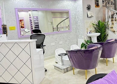 Stylish reception and seating area at SAbeauti Professional Ladies Salon, Dubai, AE, featuring purple chairs.