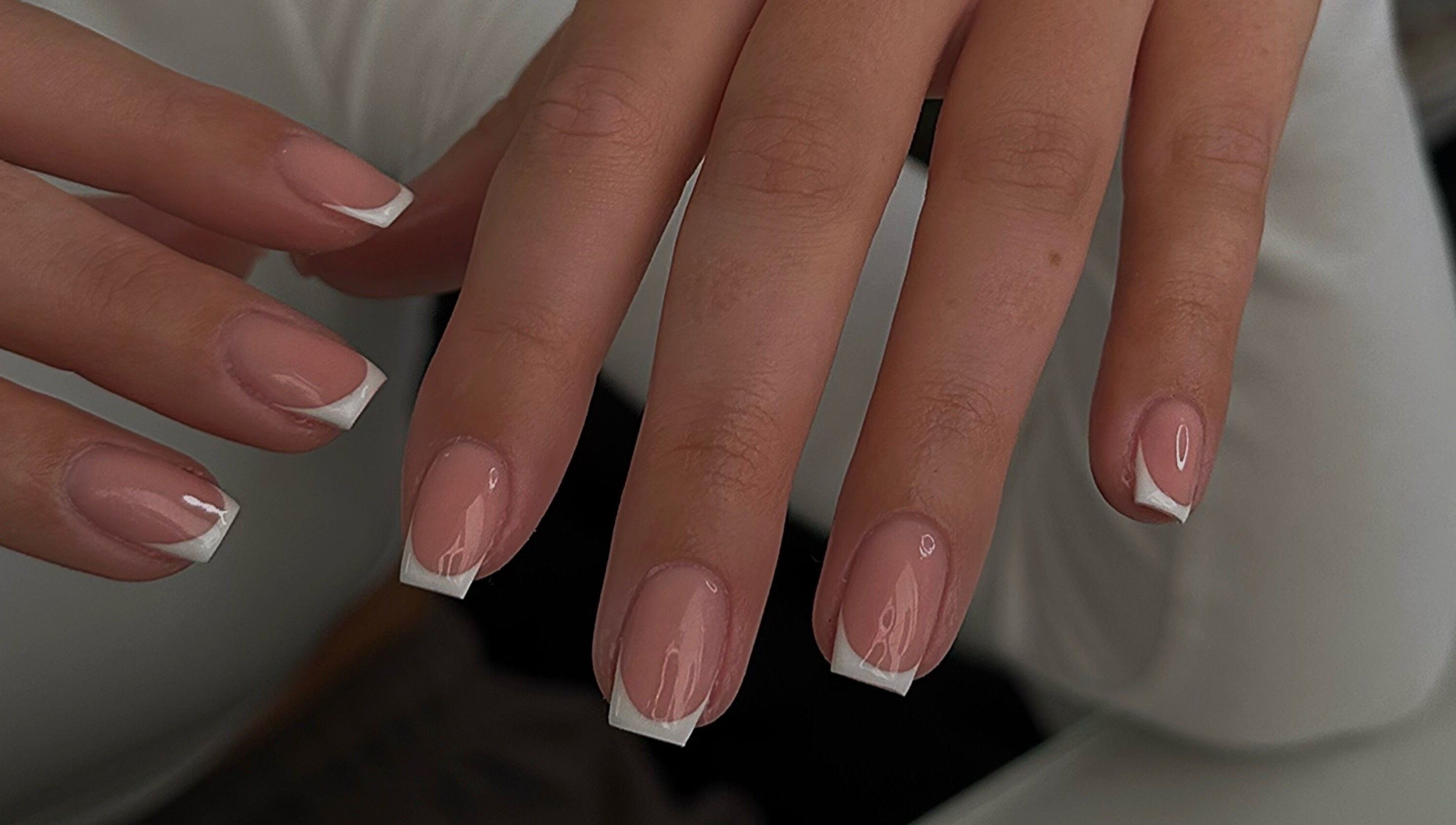Elegant French manicure on fingernails at A.B Studio, Cardiff, Wales, GB, showcasing beauty services.