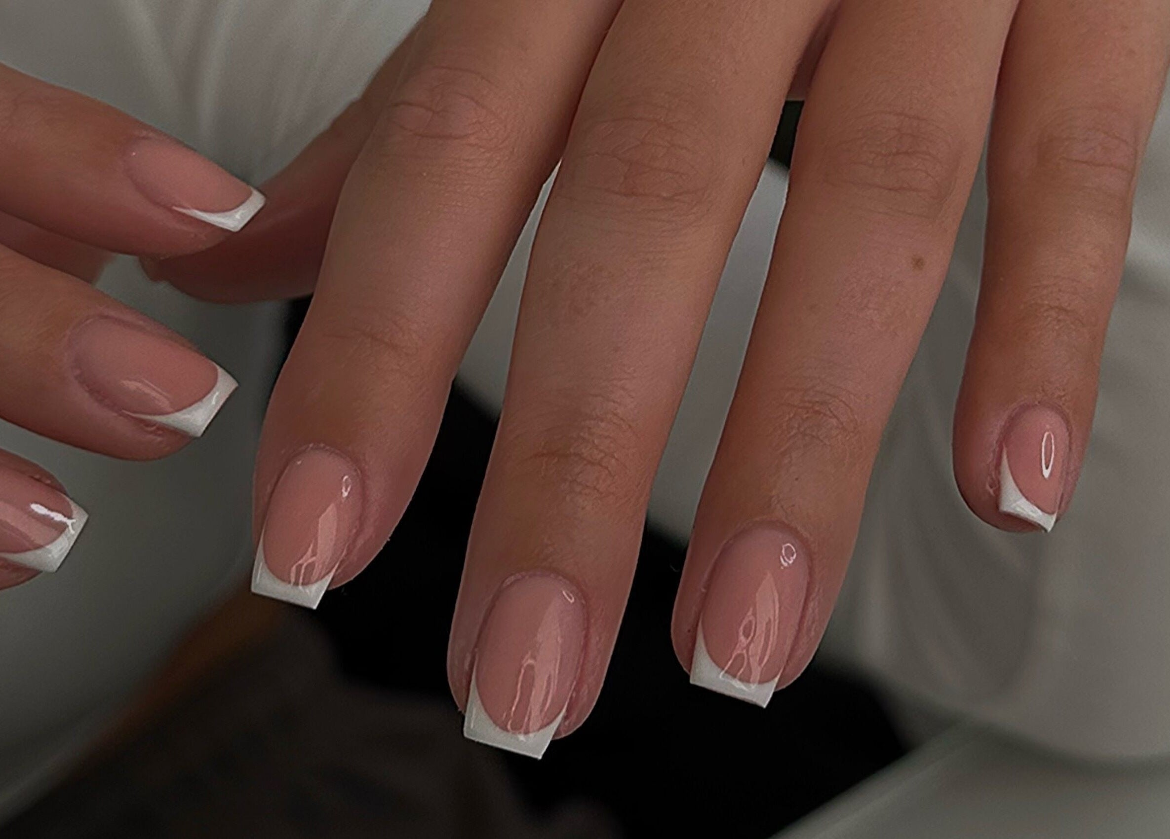 Elegant French manicure on fingernails at A.B Studio, Cardiff, Wales, GB, showcasing beauty services.