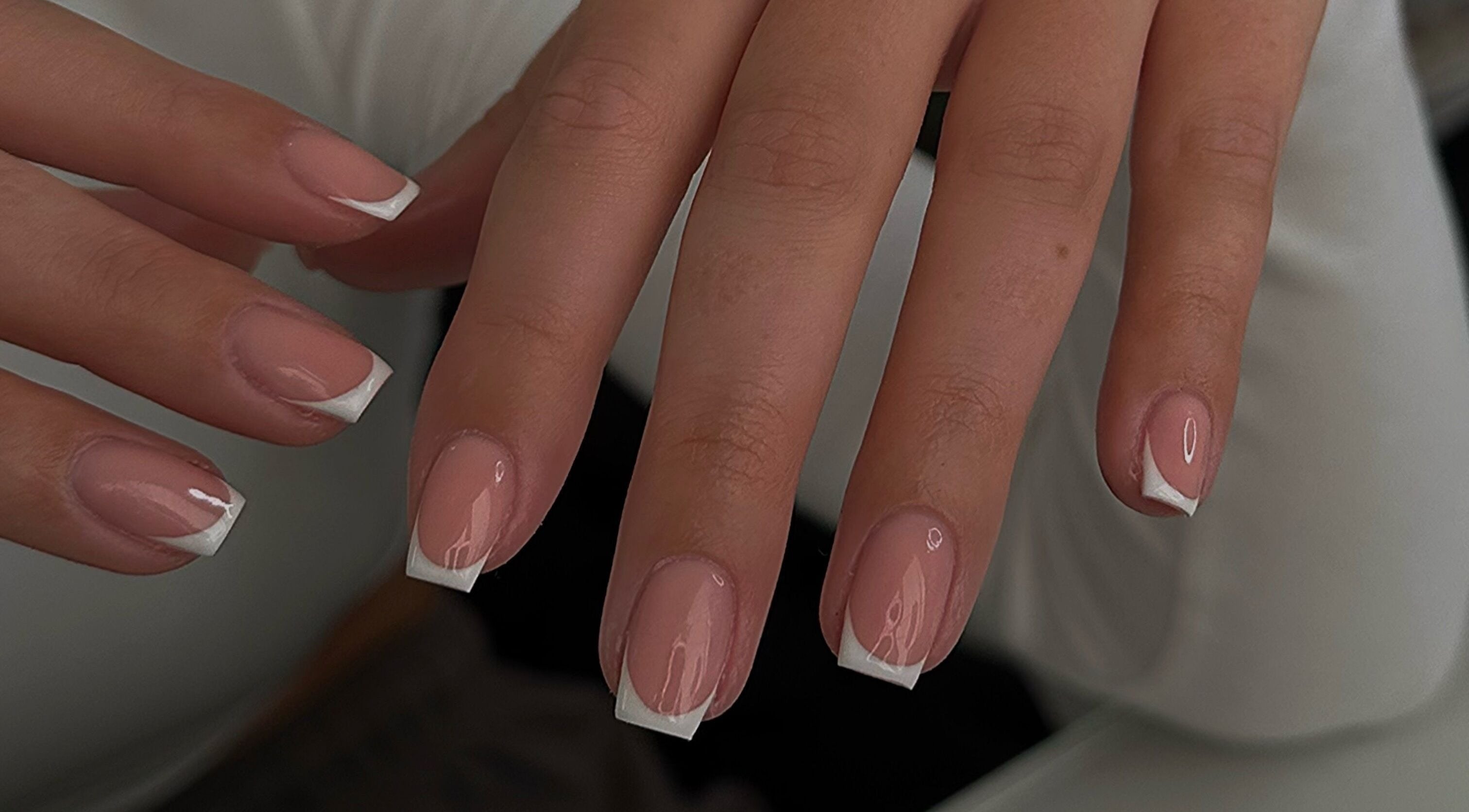 Elegant French manicure on fingernails at A.B Studio, Cardiff, Wales, GB, showcasing beauty services.