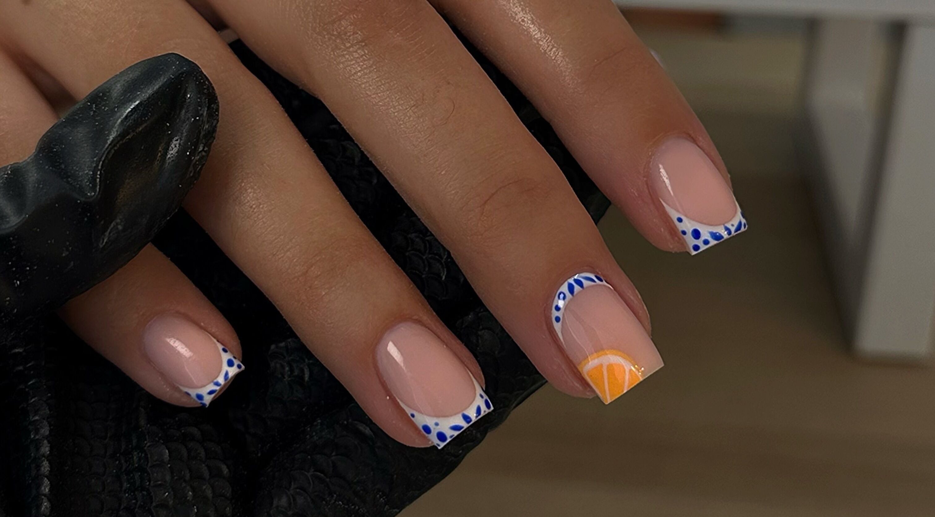 Creative nail design with blue and orange art at A.B Studio, Cardiff, Wales, GB.