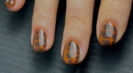 Stylish tortoiseshell nails by Nails by Jen in St Helens, England, GB on black background.
