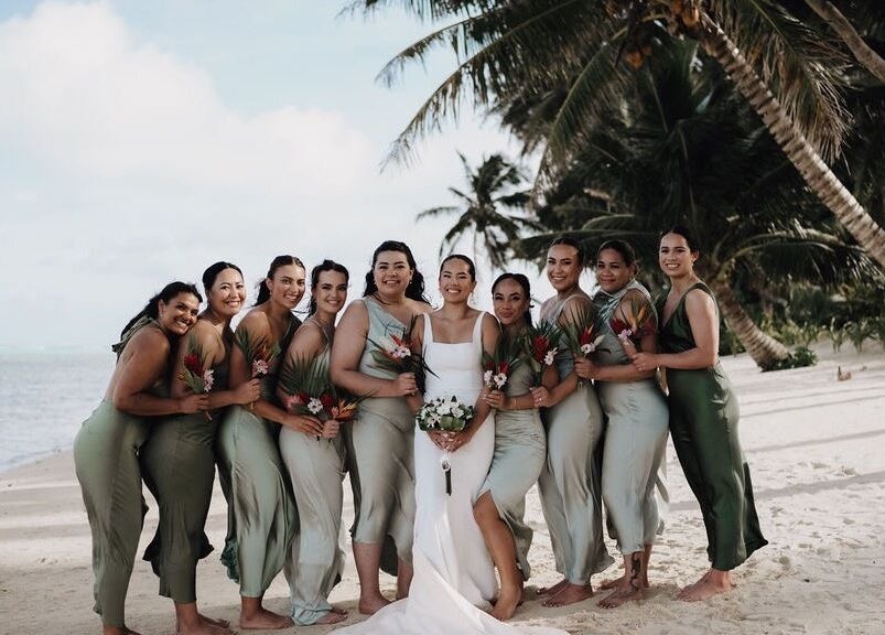 Bridal party on tropical beach by Image by Imogen, Auckland, Auckland, NZ. Bridesmaids in green dresses with palm trees.
