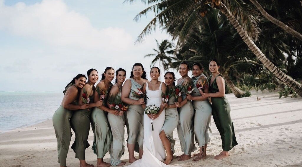 Bridal party on tropical beach by Image by Imogen, Auckland, Auckland, NZ. Bridesmaids in green dresses with palm trees.