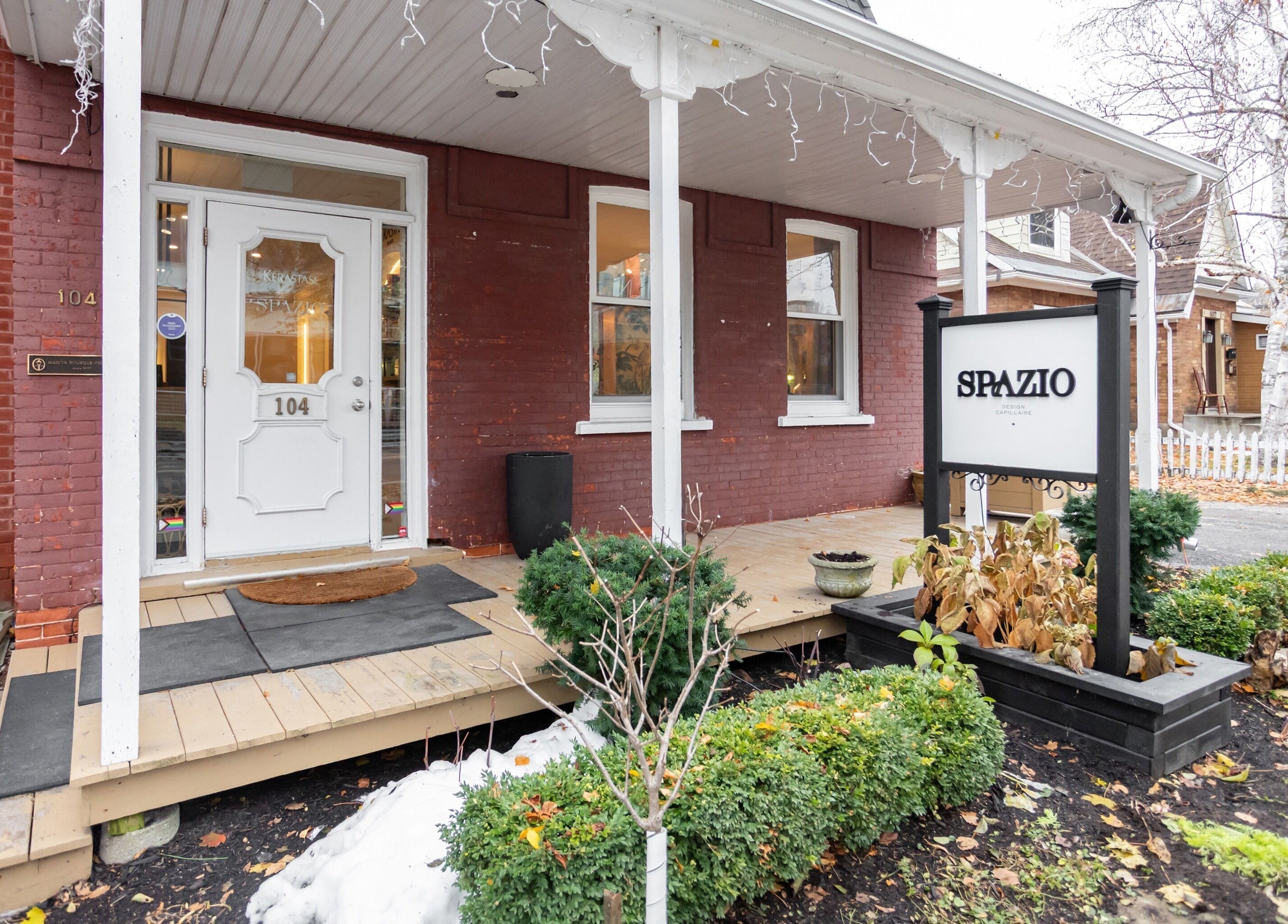 Entrée de Spazio Design Capillaire à Gatineau, Québec, CA, avec façade en briques et signalétique accueillante.