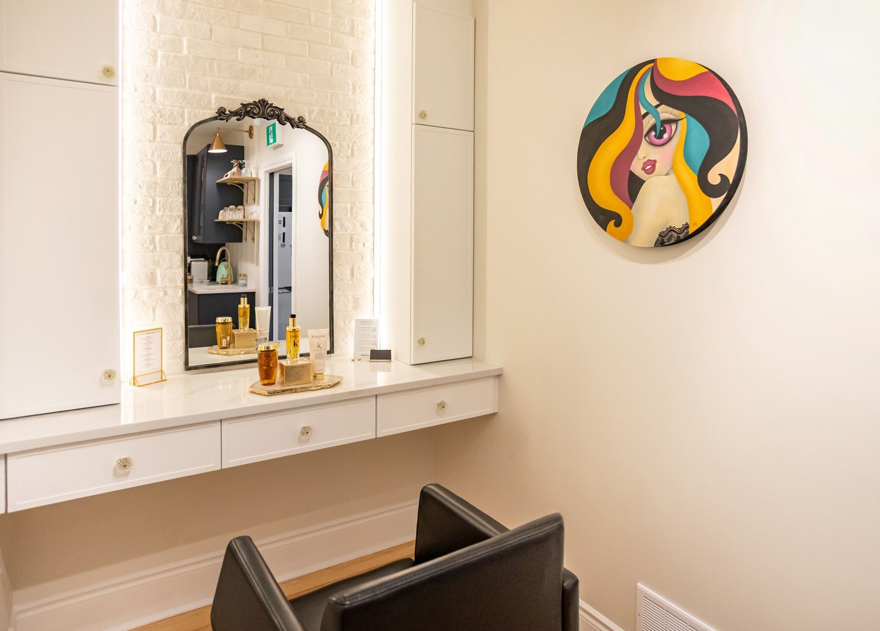 Salon chic chez Spazio Design Capillaire, Gatineau, Québec, CA, mettant en valeur un miroir et une œuvre d'art.