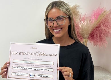 Graduate holding certificate of lymphatic drainage from By Beauty Academy, Manchester, England, GB.