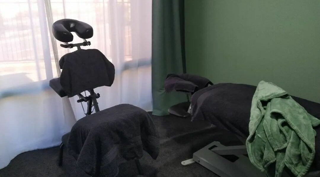Massage chair and bed at Eucalypt Remedial Massage, Wellard, Western Australia, AU, in a serene green room.