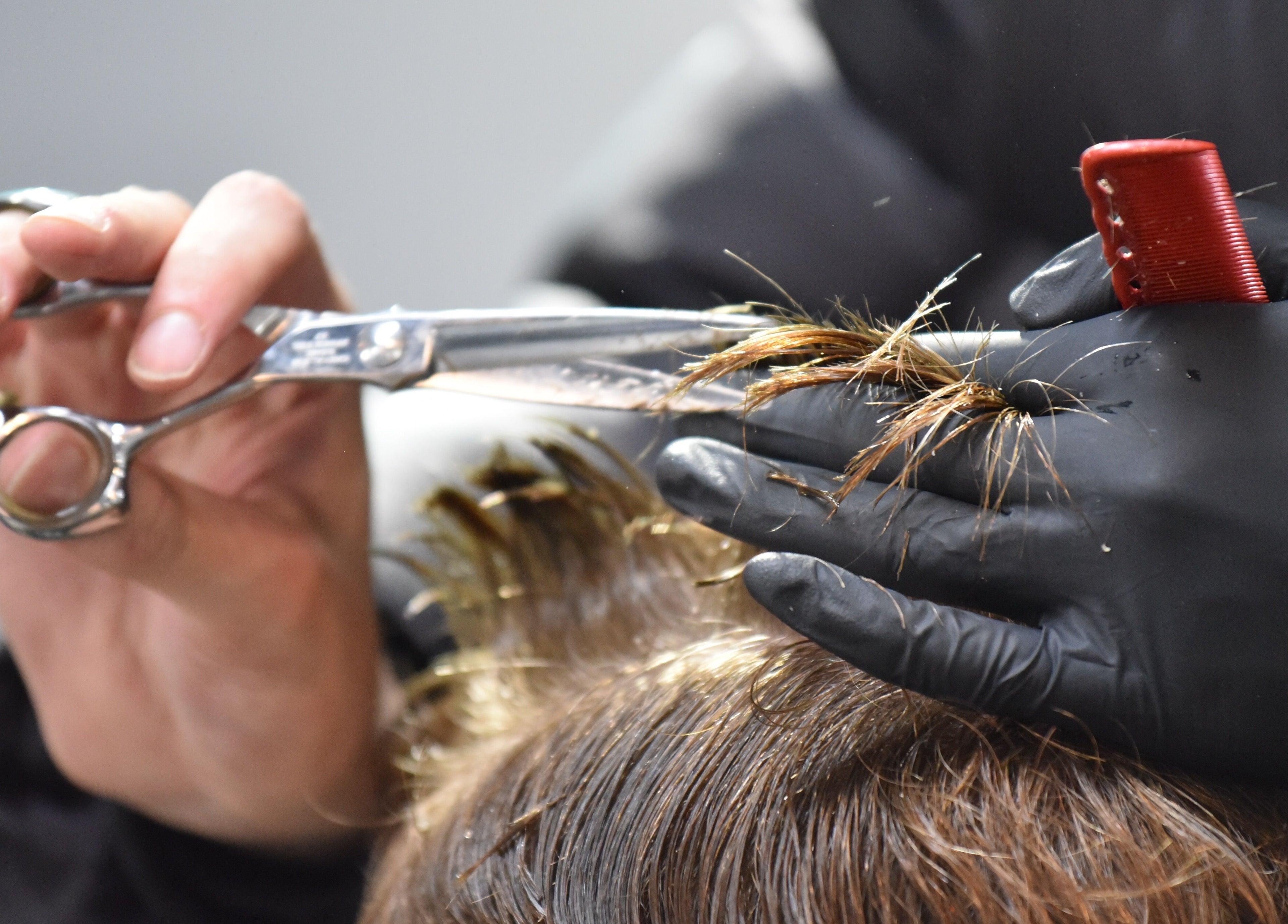 A stylist trims hair with scissors at The Barbershop Braddon, Braddon, Australian Capital Territory, AU.