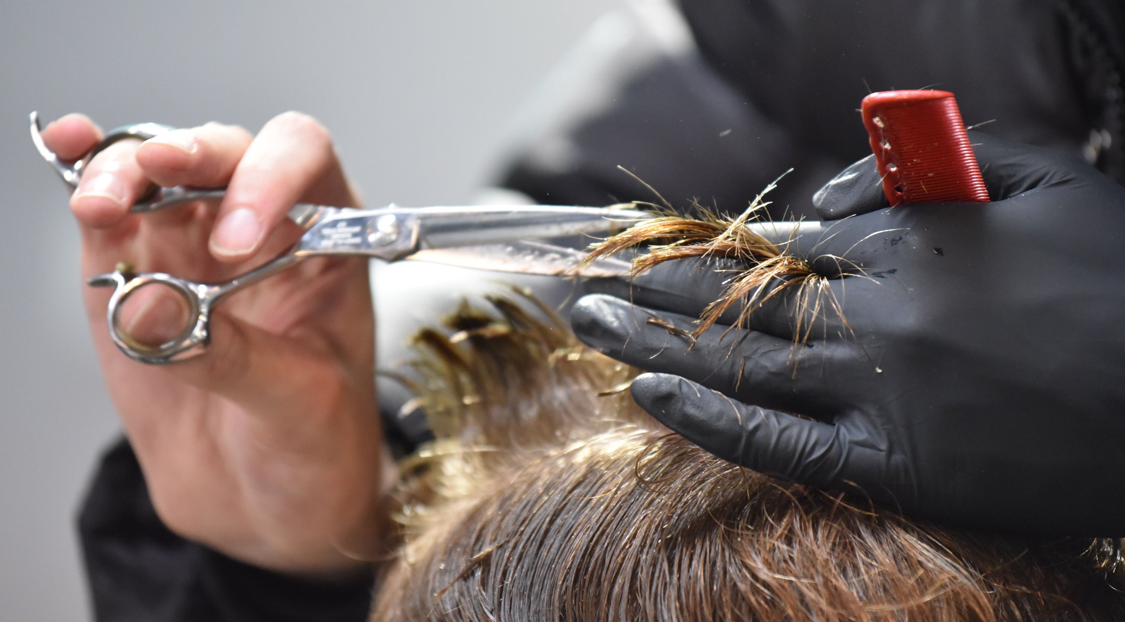 A stylist trims hair with scissors at The Barbershop Braddon, Braddon, Australian Capital Territory, AU.