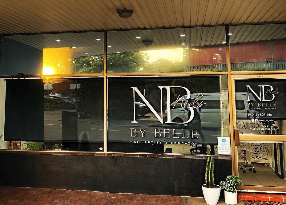 Front view of Nails by Belle with its logo at Budgewoi, NSW, AU, showcasing a stylish glass entrance.