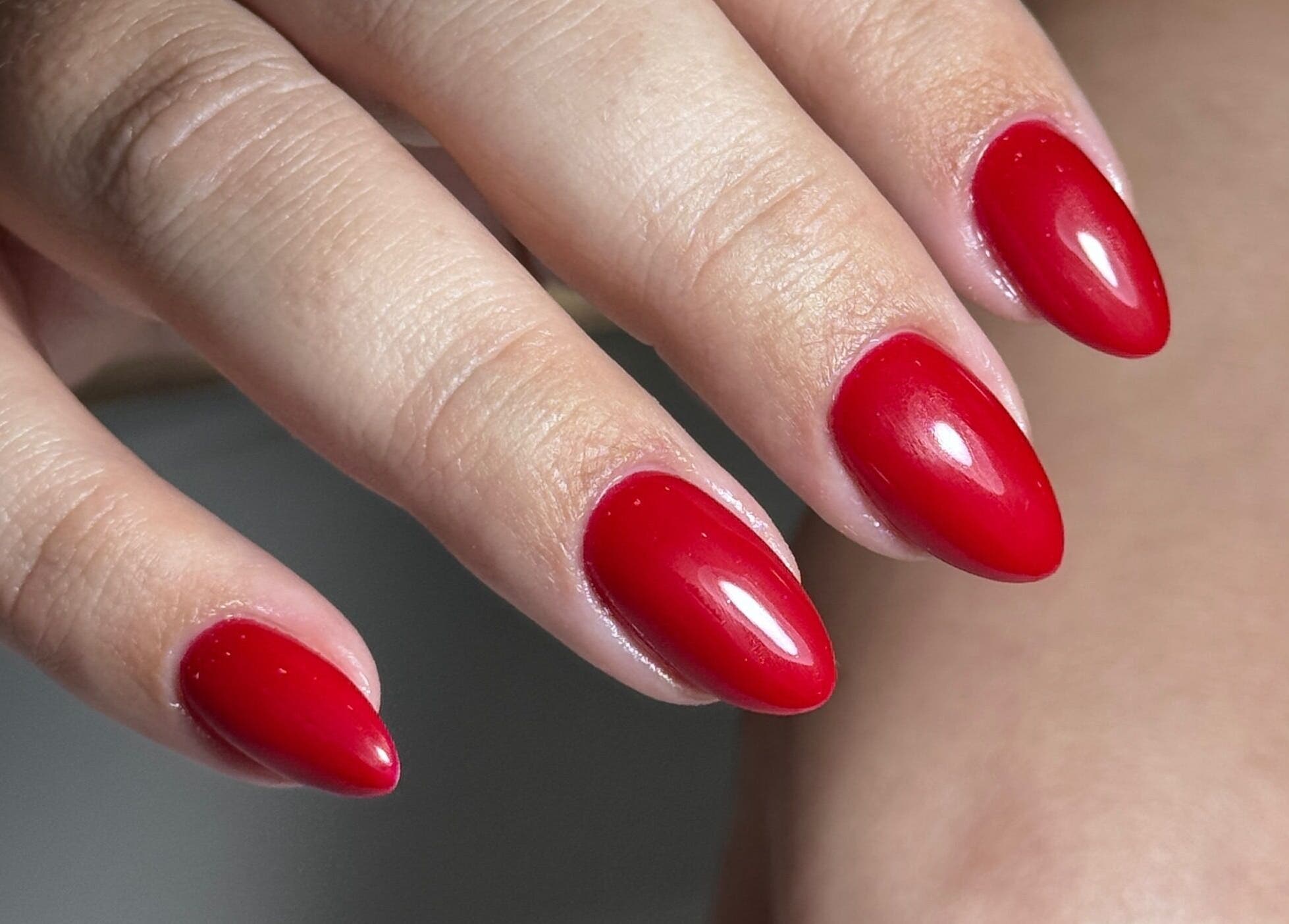 Red gel manicure at Nails by Belle, Budgewoi, NSW, AU showcases elegant hand and nail art.