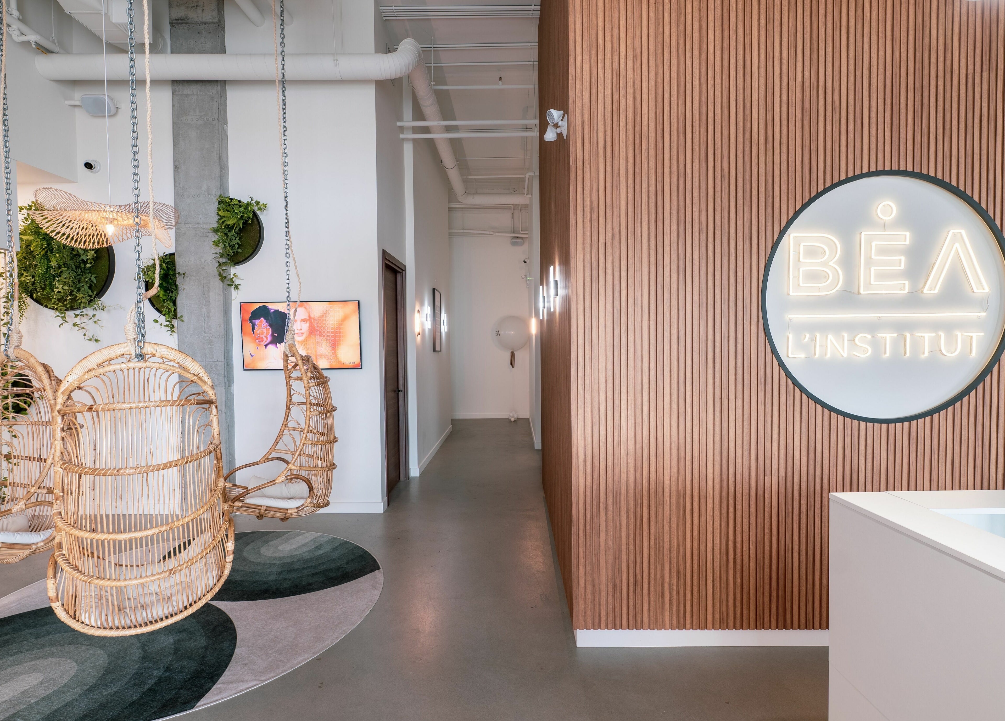 Elegant interior of L'Institut Béa in Laval, Québec, CA featuring inviting wicker swings and modern decor.