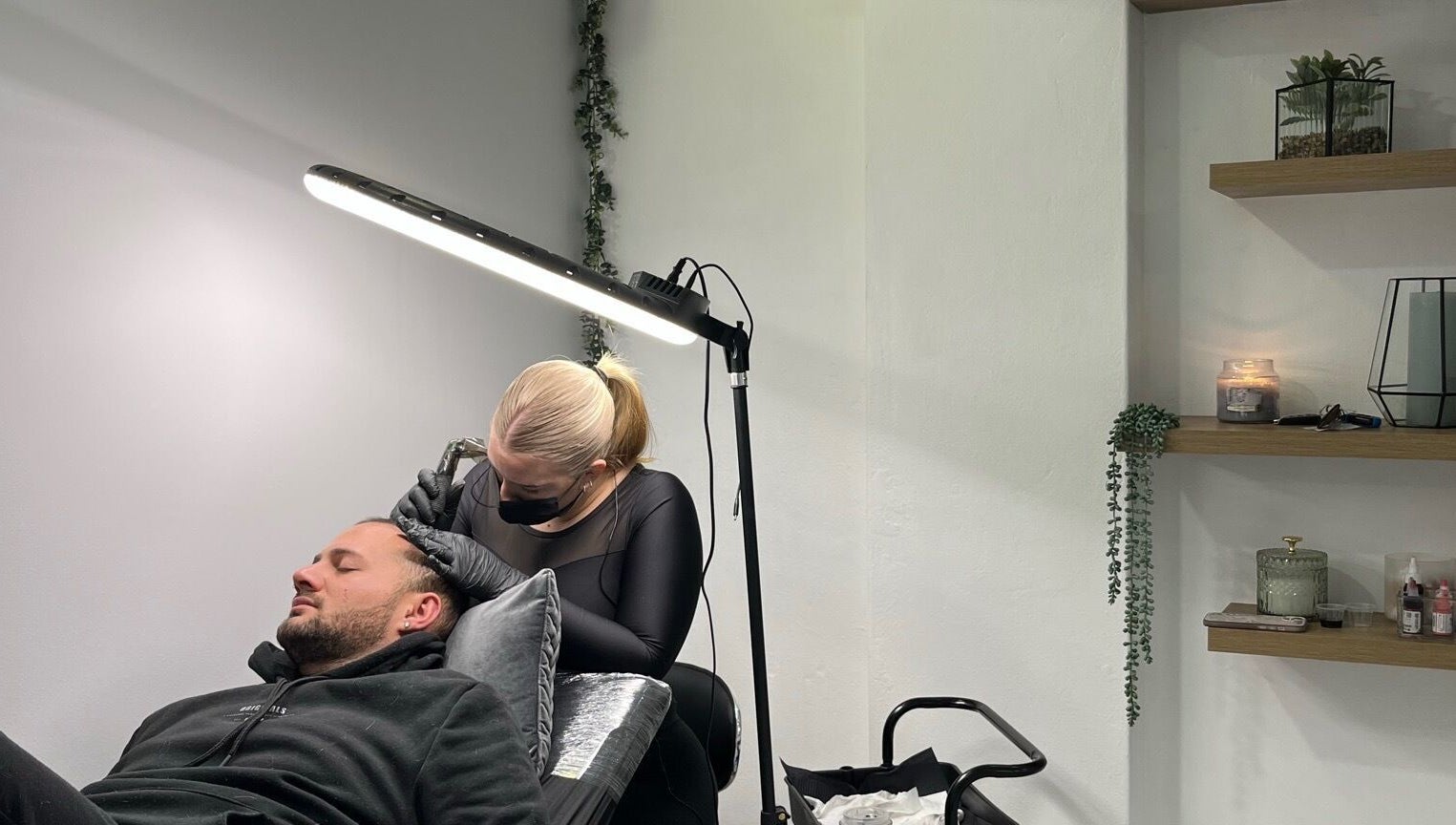 Scalp micropigmentation session at Scalpture Ink, Johannesburg, Gauteng, ZA in a calm, well-lit room.
