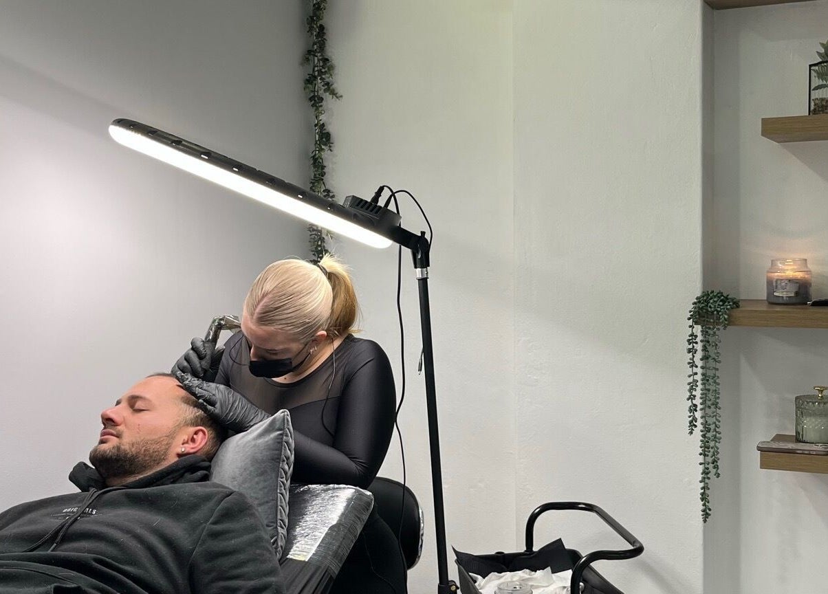 Scalp micropigmentation session at Scalpture Ink, Johannesburg, Gauteng, ZA in a calm, well-lit room.