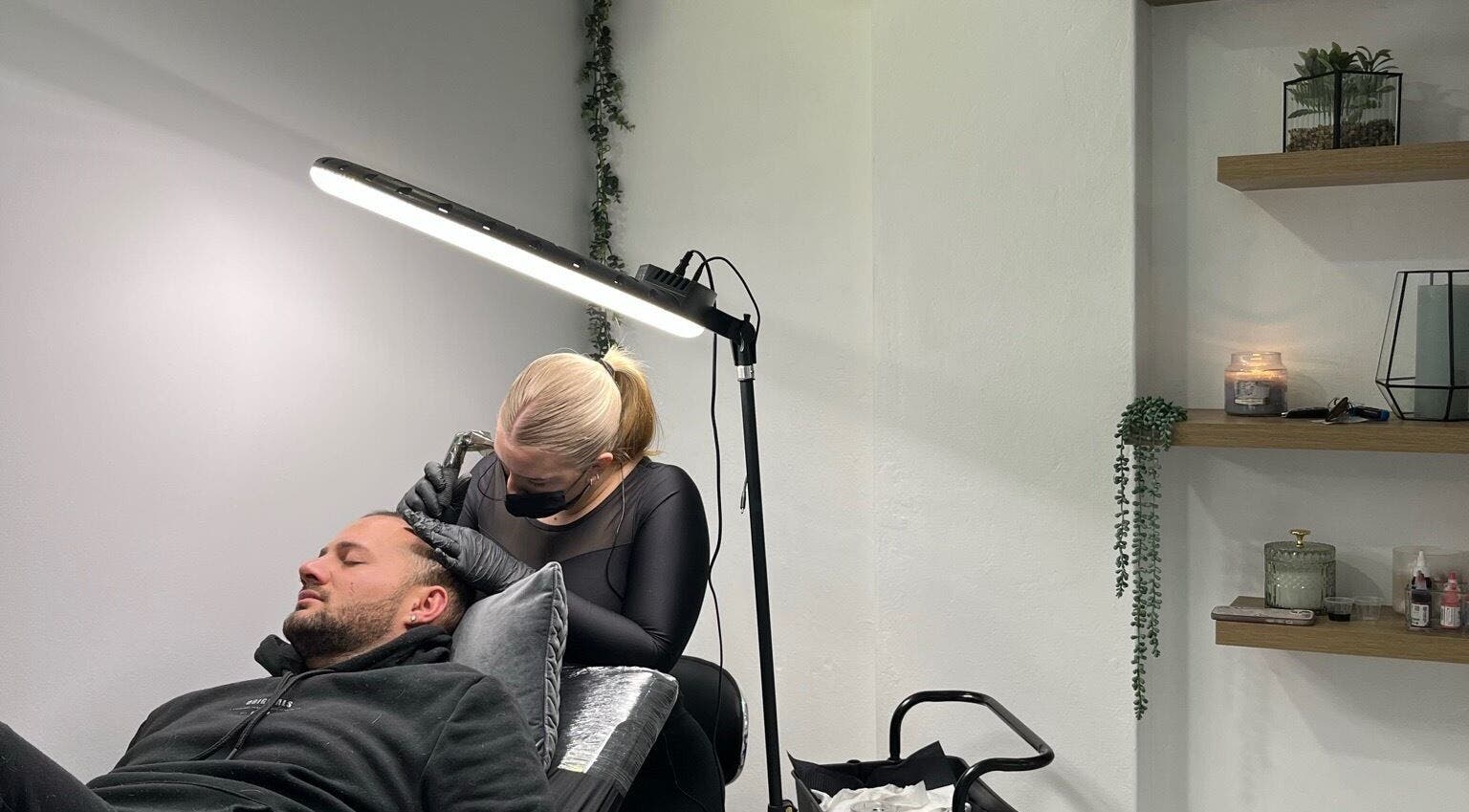 Scalp micropigmentation session at Scalpture Ink, Johannesburg, Gauteng, ZA in a calm, well-lit room.