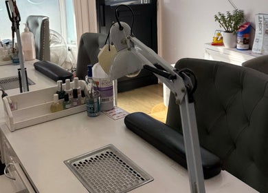 Modern manicure station at Kaites Nails, Twickenham, England, GB, with cozy chairs and nail care products.