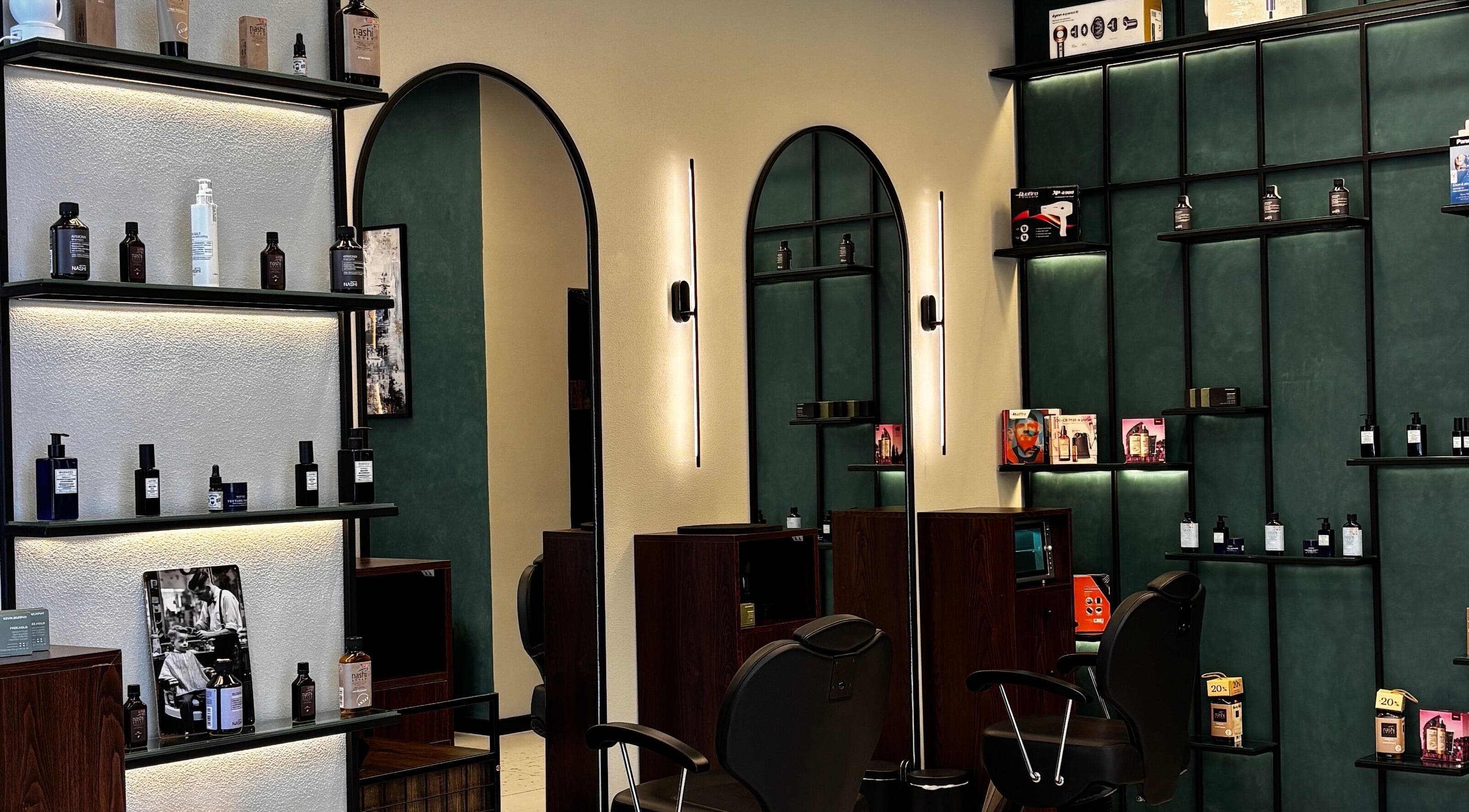 Modern interior of 717 Gents Salon | Dubai Hills featuring sleek shelves and elegant chairs in Dubai, Dubai, AE.