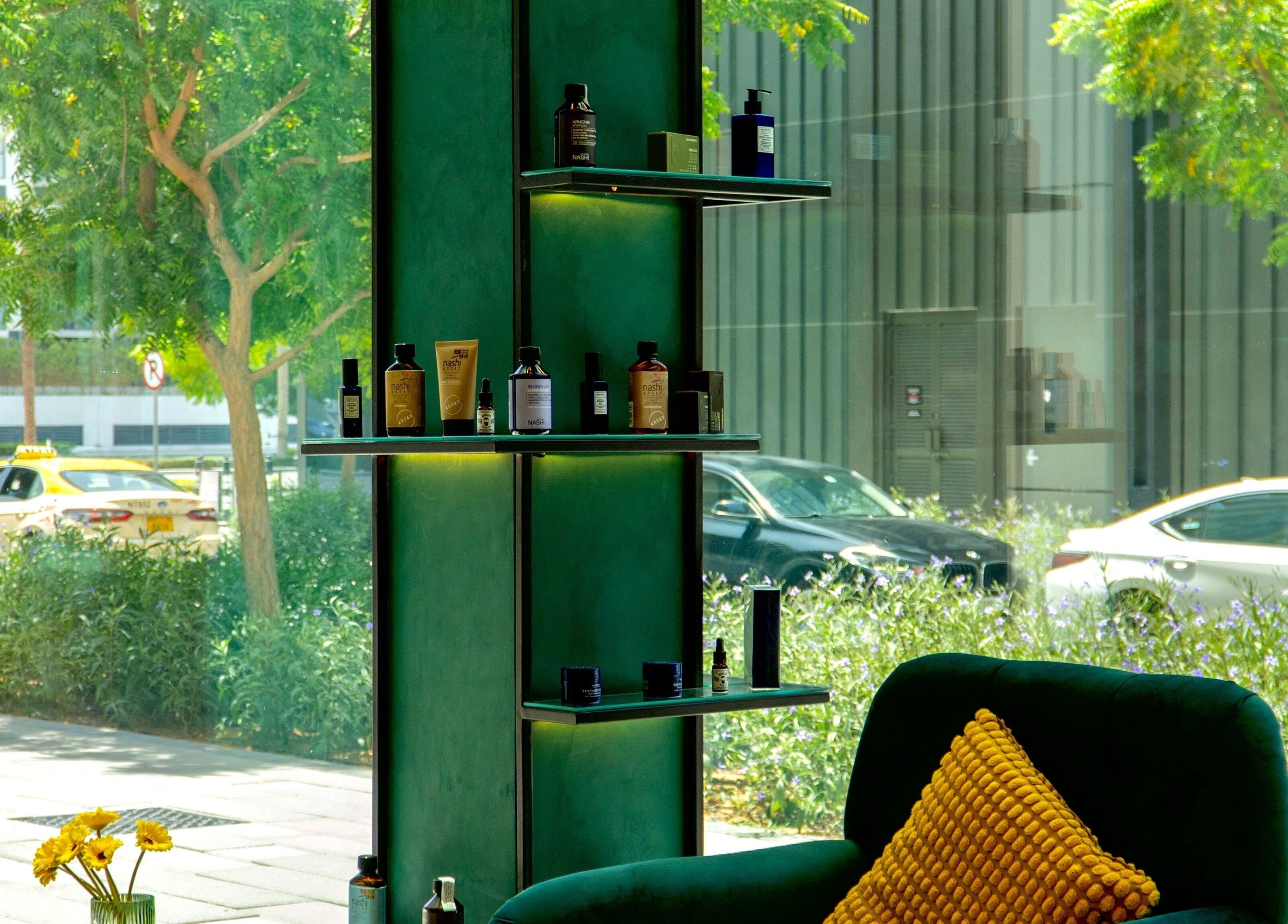 A cozy seating area with plush cushions and product display at 717 Gents Salon | Dubai Hills, Dubai, Dubai, AE.