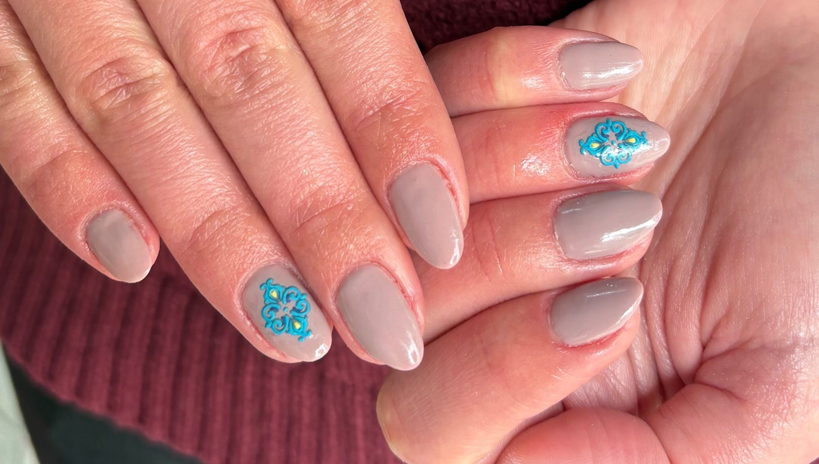 Elegant beige nails with blue floral art at Kim’s Beauty Center, Iż-żurrieq, MT.