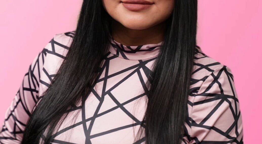 Close-up of a person with long hair and a geometric-patterned top at Bare Kitty Wax, Inverness, Illinois, US.