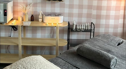 Warm and inviting treatment room at Sundara Beauty, Jubilee Pocket, Queensland, AU with a grey massage table.