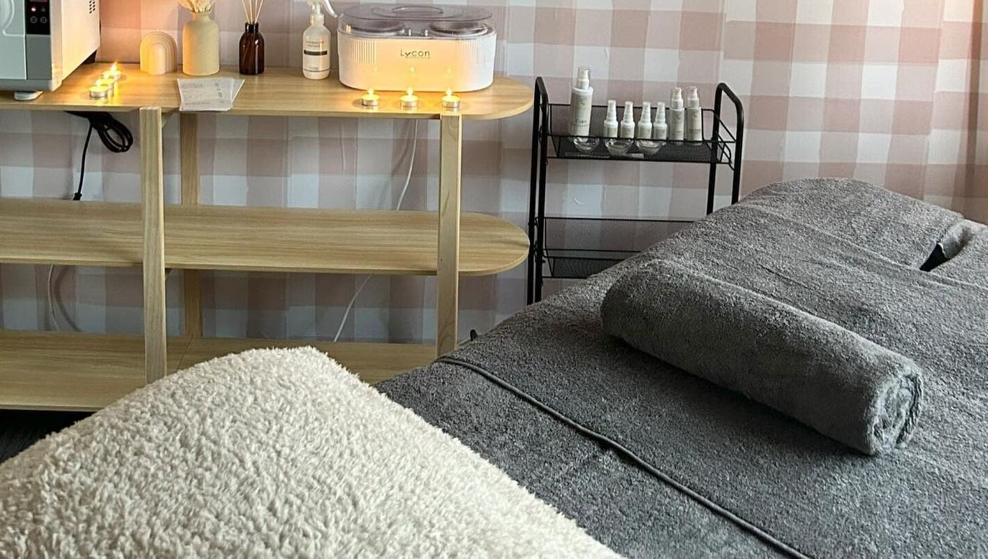 Relaxing treatment room at Sundara Beauty in Jubilee Pocket, Queensland, AU, with candles and cozy setup.