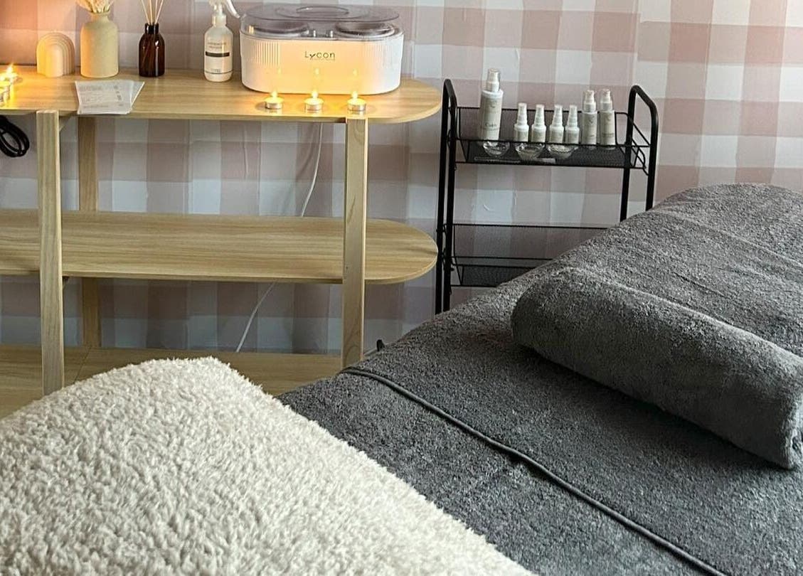 Relaxing treatment room at Sundara Beauty in Jubilee Pocket, Queensland, AU, with candles and cozy setup.