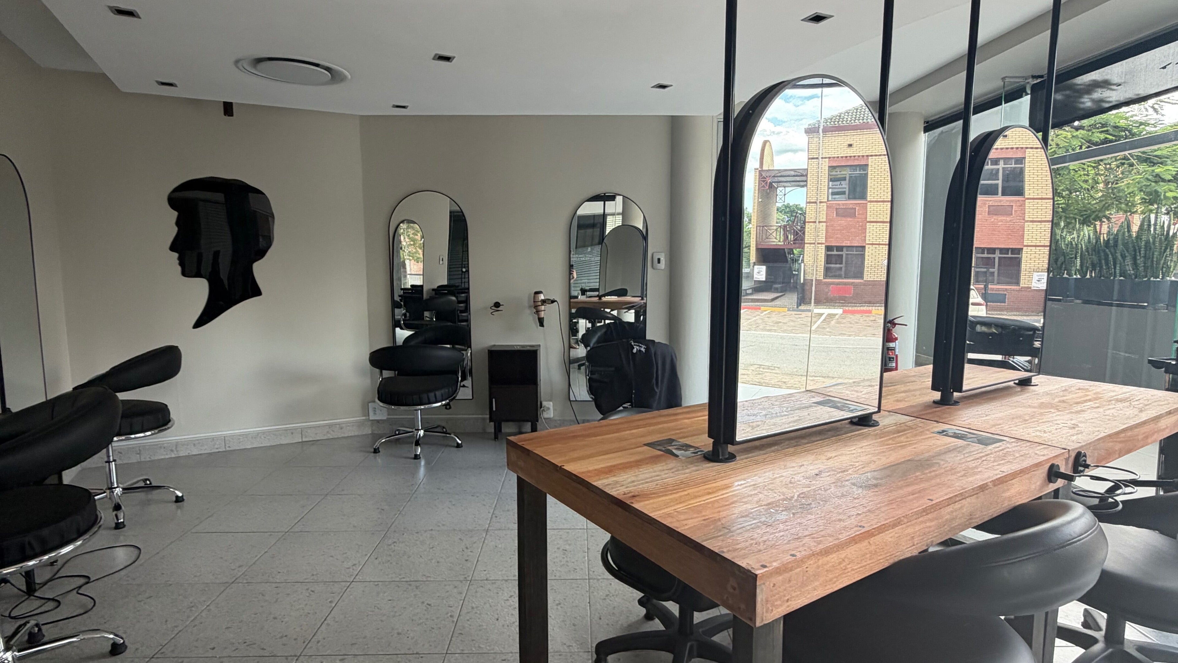 Modern salon interior at Rock Paper Scissors Nelspruit in Mbombela, Mpumalanga, ZA with stylish mirrors and chairs.