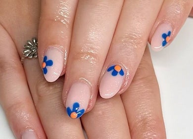 Elegant floral nail art at HCM Nails, Falmouth, England, GB showcasing blue and orange flower designs.