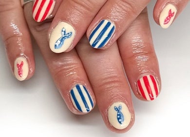 Nautical-themed nail art at HCM Nails, Falmouth, England, GB. Red stripes and blue anchors design.